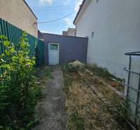 Rodinný dům na Rybničné ulici ve Velké Mači, úzký dvůr se zelení a betonovým chodníkem.