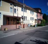 Rodinný dům v Novácích s předzahrádkou a upraveným chodníkem podél cesty.