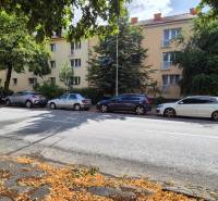 Budova na ulici Pod Párovcami v Piešťanech, obklopená stromy a zaparkovanými auty.