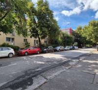 Ulice Pod Párovcami v Piešťanech s auty parkujícími před 3pokojovým bytem ve stínu stromů.