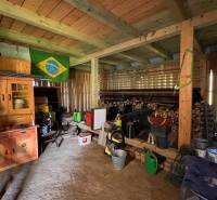 Interiér garáže v rodinném domě s různým nářadím a brazilskou vlajkou na stěně.