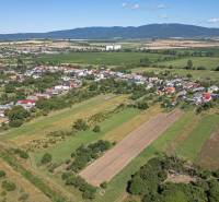 Panoramatický pohled na Sečovce s rozlehlými pozemky na bydlení a okolními poli.