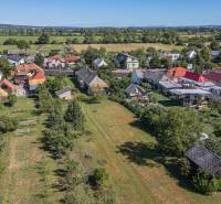 Letecký pohled na Pozemky - bydlení v Sečovcích obklopené zelení a rozptýlenými domy.