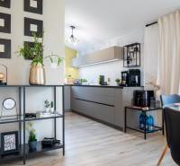 Interiér rodinného domu s otevřenou kuchyní, moderním nábytkem a dekoracemi.