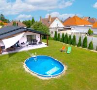 Rodinný dům v Černé Vodě s bazénem na zeleném trávníku a terasou.