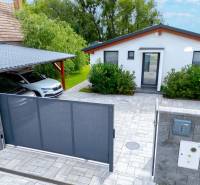 Rodinný dům v Černé Vodě s autem, bránou a upravenou zahradou.