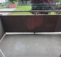 Balkon s dlážděnou podlahou a výhledem na zeleň v 2-pokojovém bytě Liptovského Mikuláše.