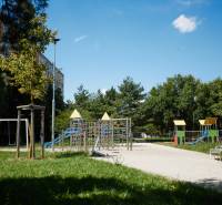 Dětské hřiště obklopené zelení a paneláky, Košice - městská část Jih.