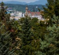 Panoráma Košic s pohledem na historické budovy obklopené zelení a horami v pozadí.