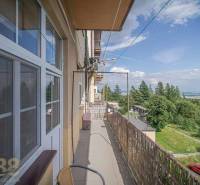 Balkon 3pokojového bytu ve Vysokých Tatrách s výhledem na přírodu a parkoviště.