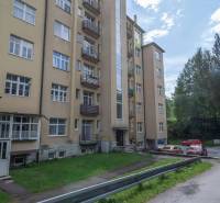 Pětiposchoďový bytový dům ve Vysokých Tatrách s přístupovou cestou a parkováním.