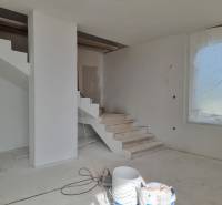 Schodiště ve vile během renovace, vedle velkého okna se zakrytým výhledem.