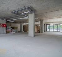 Obchodní prostory v rekonstrukci se sklem a betonem, připravené na úpravy.