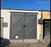 Garáže v Dunajské Stredě s ocelovou bránou a elektrickým boxem na stěně.
