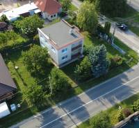 Rodinný dům v Rakoľubech v Novém Městě nad Váhem obklopený zelení a ulicí.