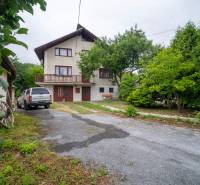 Rodinný dům v Daleticích, na ulici Daletice, obklopený stromy se zaparkovaným autem na dvoře.