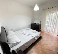 Ložnice v rekreačním apartmánu s manželskou postelí, komodou a balkonem.