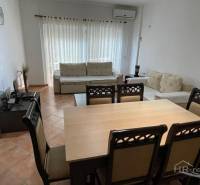 Obývací pokoj s jídelním stolem a pohovkou v rekreačním apartmánu.