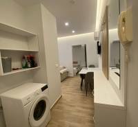 Praktické uspořádání s pračkou a jídelním stolem v Rekreačním apartmánu.