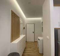 Útulný interiér rekreačního apartmánu s pračkou a úložným prostorem.
