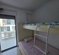 Patrová postel v ložnici rekreačního apartmánu, s výhledem na balkon.