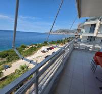 Balkon rekreačního apartmánu v Sarandë s výhledem na modré moře a pobřeží.