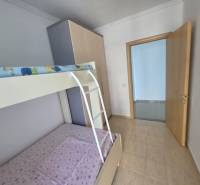 Dětský pokoj s patrovou postelí v rekreačním apartmánu má světlé stěny a podlahy.