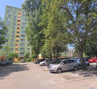 Parkoviště v Bratislavě - Petržalce na ulici Osuského s výhledem na bytové domy a zeleň.