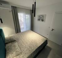 Rekreační apartmán s pohodlnou postelí, klimatizací a balkonovými dveřmi s výhledem.