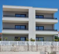 Bytový dům ve městě Vodice se třemi patry a prosklenými balkóny.