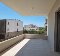 Balkon s výhledem na sousední budovy ve Vodicích nabízí prostor k odpočinku.