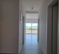 Koupelna ve 4-pokojovém bytě s chodbou a výhledem na balkon.