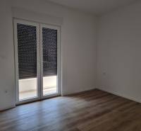 Pokoj se zataženými žaluziemi a plovoucí podlahou ve 4pokojovém bytě.
