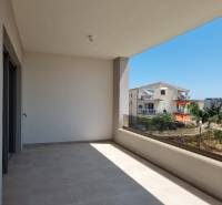 Balkon ve 4pokojovém bytě ve Vodicích s výhledem na okolní budovy a zeleň.