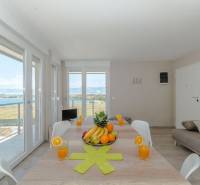 Rekreační apartmán s velkým stolem, výhledem na moře, ovocem a sklenicemi džusu.