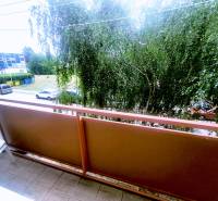 Balkon 3-pokojového bytu v Levicích s výhledem na ulici a zeleň.