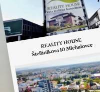 Pohled na budovu reality house, kancelář Michalovce, rodinné domy v pozadí.