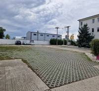 Parkoviště na ulici Šamorínská u skladů a hal, s označením realitní kanceláře.