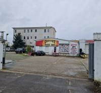 Budova Convoy Truck Shop na ulici Šamorínska, obklopená zaparkovanými auty u skladu a hal.