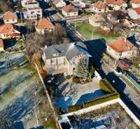Vila na ulici Sportovců v Topoľčanech, obklopená zahradami a okolními domy.