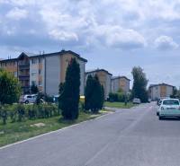 Ulice M.R.Štefánika v Mostě pri Bratislavě se zaparkovanými auty před bytovkami.
