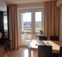 Jídelna ve 4-pokojovém bytě s přístupem na balkon a výhledem na město.