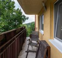 Balkon se židlemi ve 4pokojovém bytě s výhledem na zeleň.