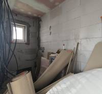 Stavební materiály a elektroinstalace v rozpracované místnosti rodinného domu.