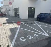 Parkovací místo na ulici Eduarda Wenzla v Bratislavě III před obchodními prostory.