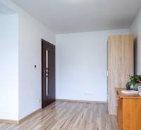 Interiér rodinného domu s dřevěnou podlahou, nábytkem a pokojovou rostlinou na stolku.