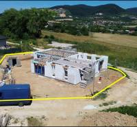 Stavba rodinného domu v Trenčianskom Jastrabí, obklopená zelení a kopci.