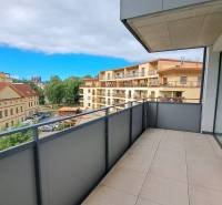 Balkon z 2-pokojového bytu na Štefánikově ulici v Popradu s výhledem na sousední budovy.