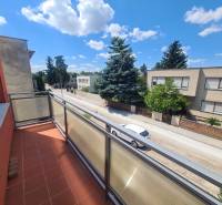 Balkon na rodinném domě v Nových Zámcích s výhledem na tichou ulici a zeleň.