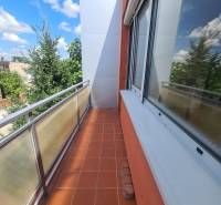 Balkon rodinného domu v Nových Zámcích s dlažbou a výhledem na stromy.